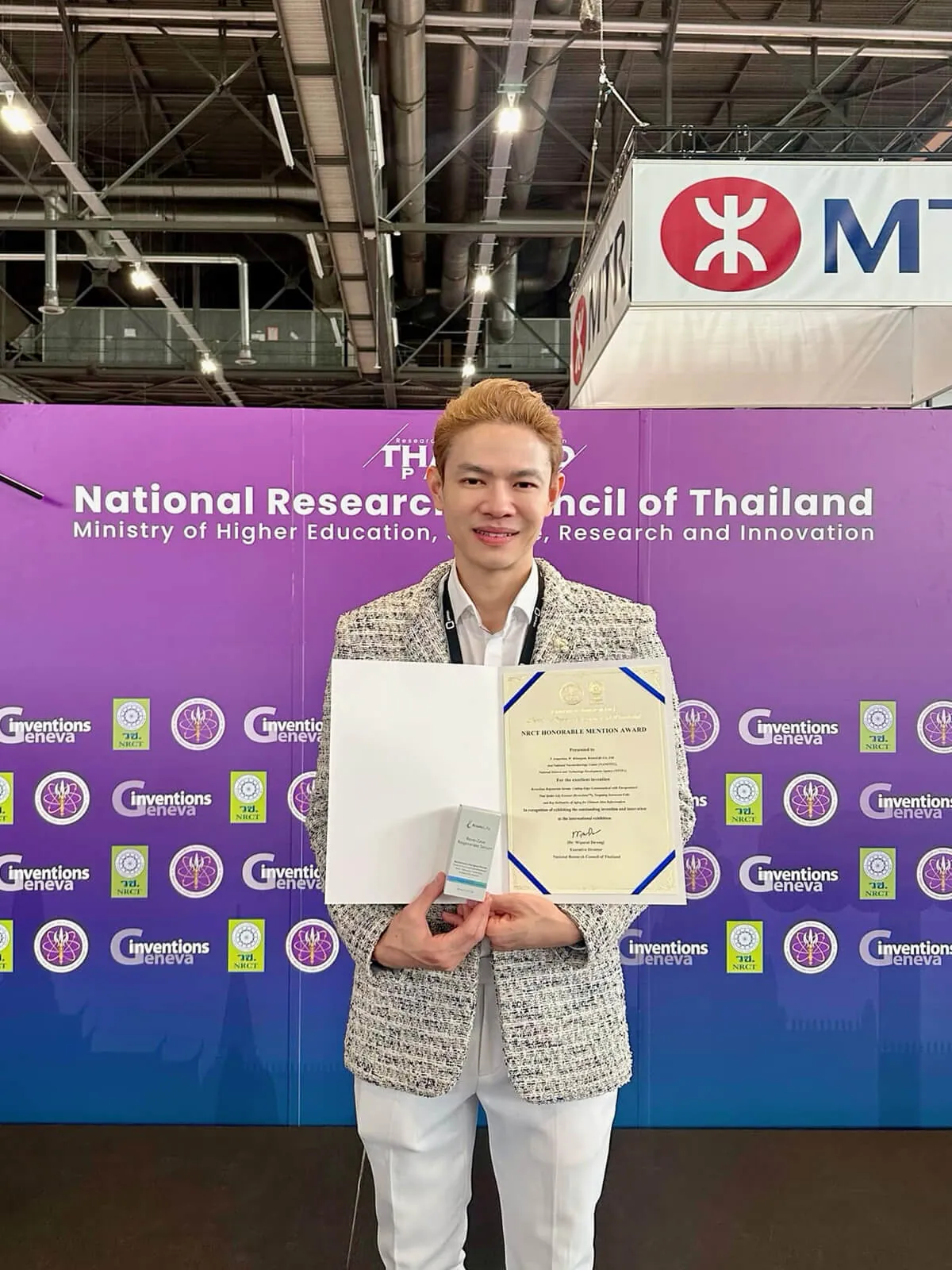 ดร.ธวิน เอี่ยมปรีดี ถือเกียรติบัตรในศาลาประเทศไทย งานสิ่งประดิษฐ์นานาชาติเจนีวา 2024